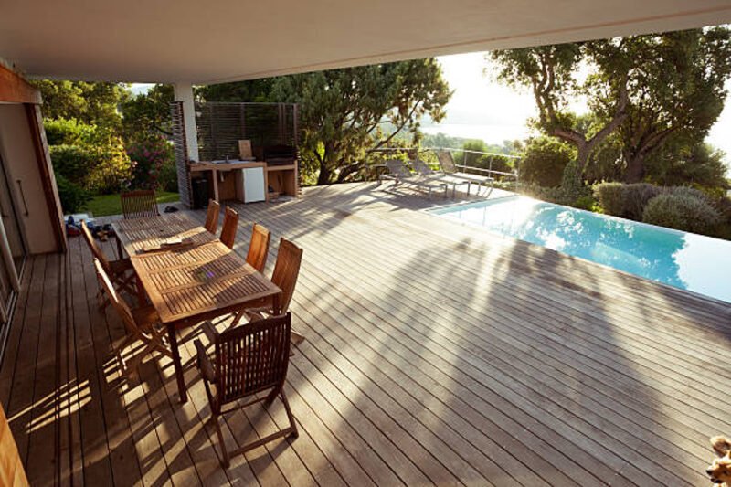 Deck de madera junto a piscina